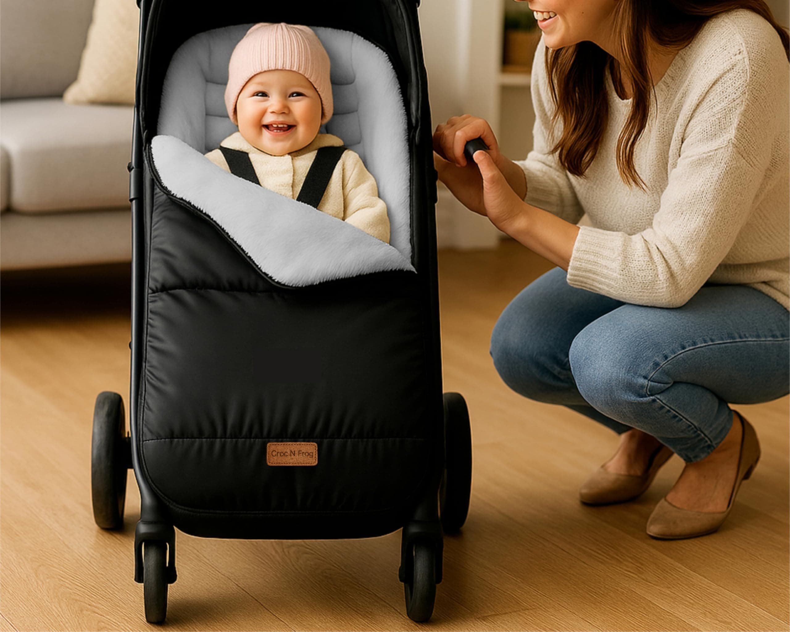 A parent smiling at a baby tucked into a Croc N Frog footmuff